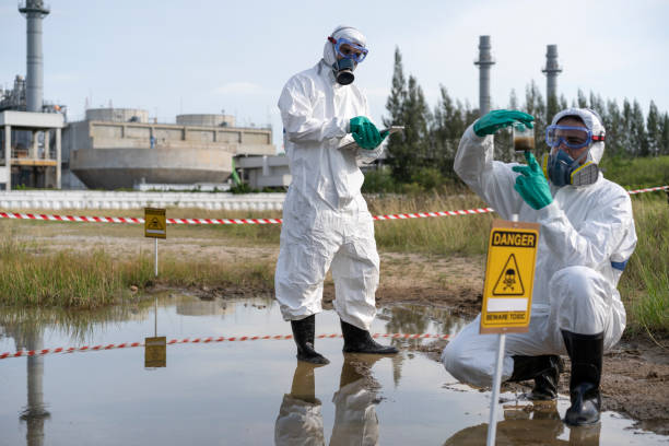 Environmental researcher taking water sample from toxic on oil spill mixed with water.